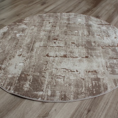 Tapete redondo bege e castanho em chão de madeira clara