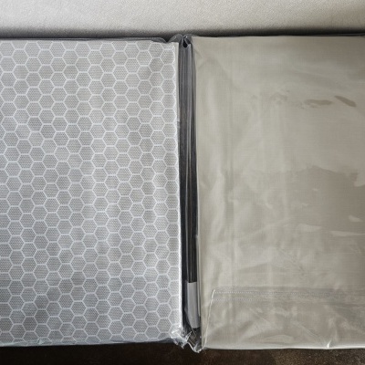 Duas capas de tecido embaladas, uma com padrão de hexágonos e outra lisa cinza claro