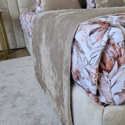Cama com colchão floral e roupa de cama bege em ambiente interior