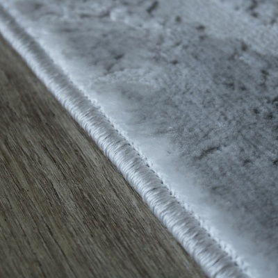 Close-up borda tapete cinza claro textura aveludada piso madeira clara