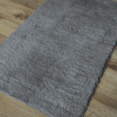 Tapete cinza macio sobre chão de madeira clara