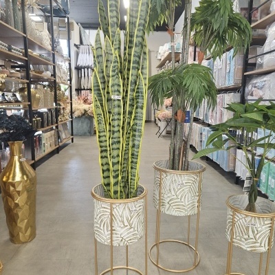 Plantas artificiais em vasos decorativos com etiquetas de preço numa loja de artigos para casa