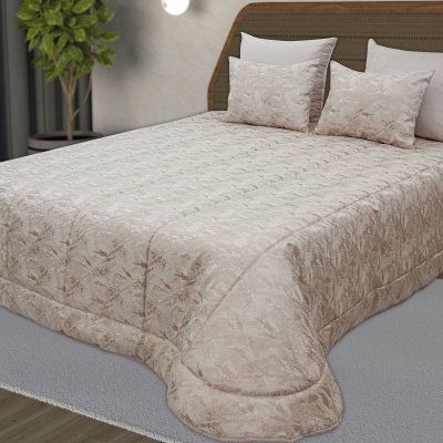 Colcha bege com padrão floral e almofadas numa cama com cabeceira castanha