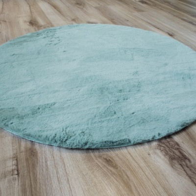 Tapete redondo azul claro sobre pavimento de madeira clara