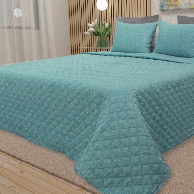 Cama com edredom azul turquesa matelassê e almofadas em quarto moderno