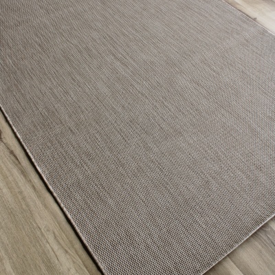 Tapete retangular bege com textura de malha sobre chão de madeira.