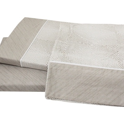 Conjunto de roupa de cama bege e branco com padrões geométricos