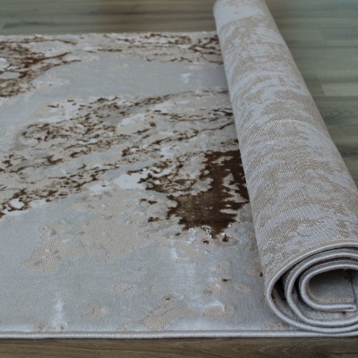 Tapete bege e castanho desenrolado sobre chão de madeira clara