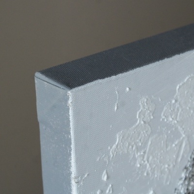 Canto de uma tela branca texturada com tinta espessa em relevo