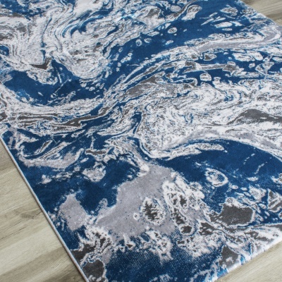 Tapete azul, branco e cinzento com padrão abstrato em chão de madeira clara