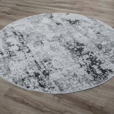 Tapete redondo cinza e branco sobre chão de madeira clara