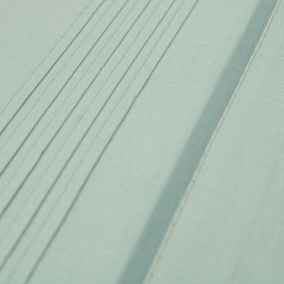 Tecido verde-água com linhas costuradas paralelas e texturas variadas