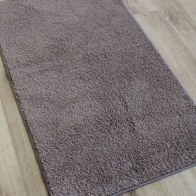 Tapete retangular cinzento felpudo em chão de madeira