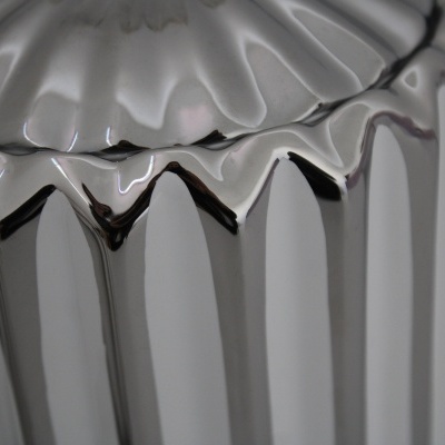 Recipiente metálico prateado com acabamento brilhante e textura canelada