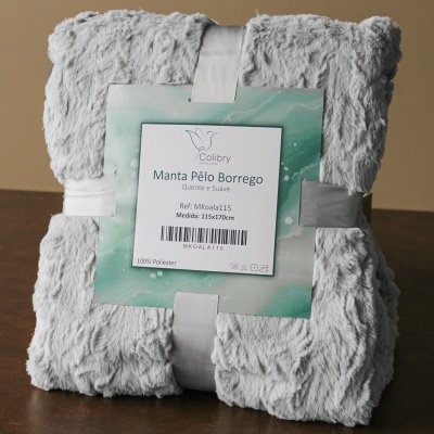 Manta cinzenta de pelo borrego dobrada com etiqueta da marca Colbtry