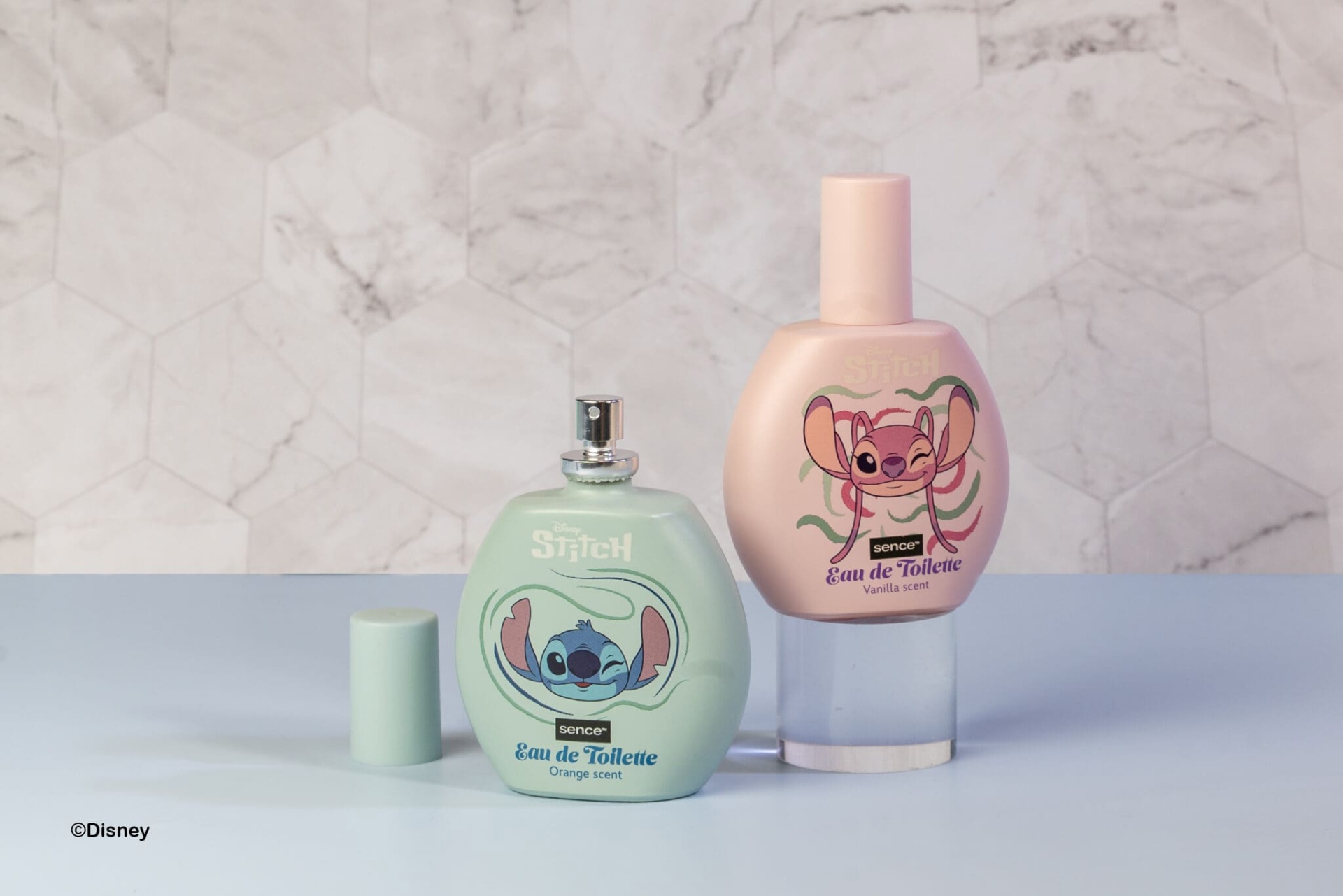 Dois frascos de Eau de Toilette Disney Stitch em cores verde e rosa sobre superfície azul claro