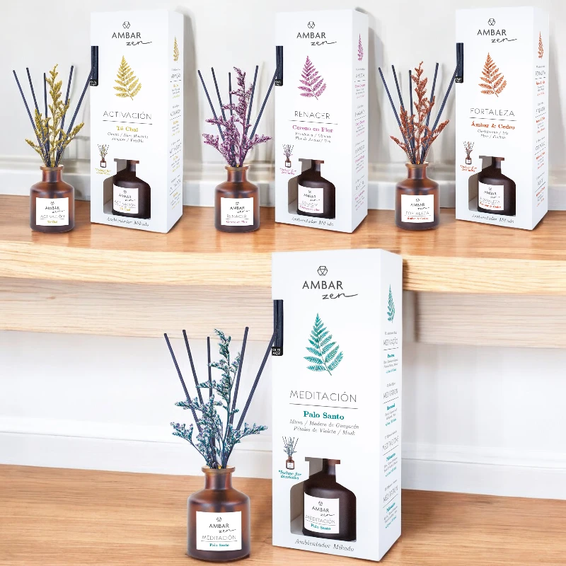 Cinco difusores AMBAR Zen com frascos âmbar e caixas brancas com folhas coloridas