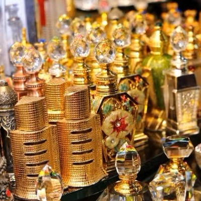 Frascos de perfume decorativos em metal dourado, prateado e bronze com tampas ornamentadas.