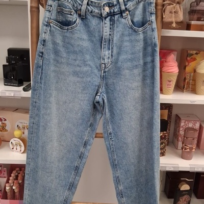 Calças de ganga azuis claras penduradas em cabide