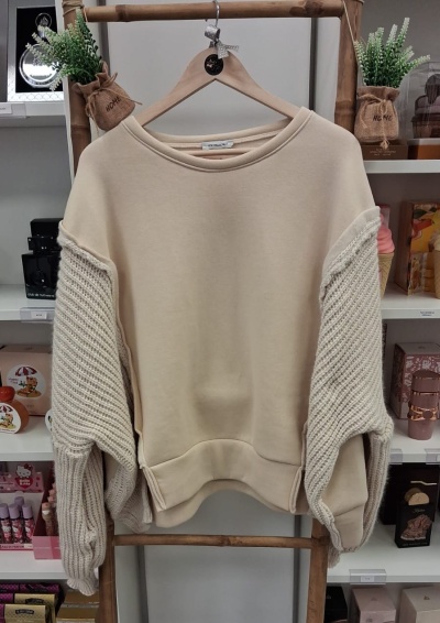 Sweatshirt bege com mangas largas em malha pendurada num cabide