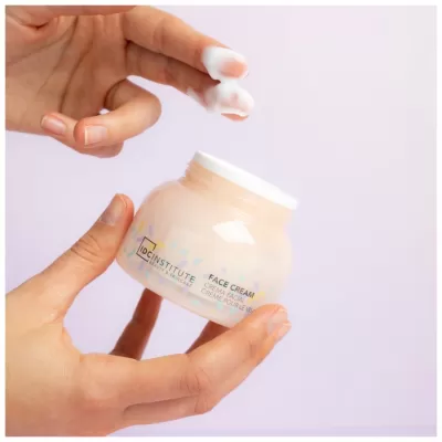 Frasco de creme facial translúcido com tampa branca e texto 'Face Cream'