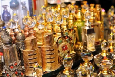 Frascos de perfume decorativos em metal dourado, prateado e bronze com tampas ornamentadas.