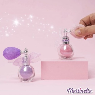 Dois frascos de perfume pequenos em vidro com puff colorido e laço, fundo rosa, texto Martinelia.