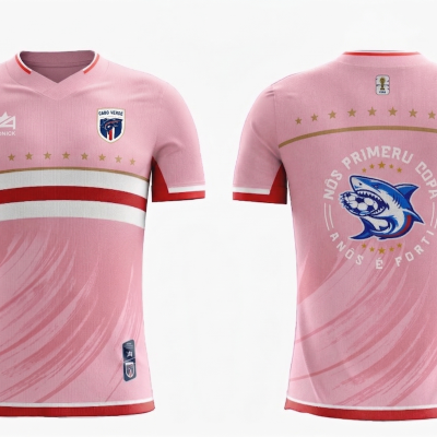 Camisola de futebol rosa com detalhes vermelhos e brancos e desenho de tubarão com bola no verso.
