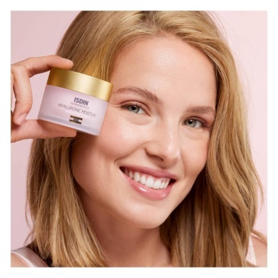 Creme facial ISDIN Hyaluronic Intensifier segurado por mulher loira sorridente