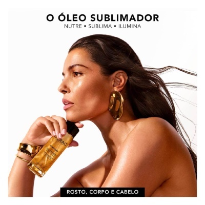 Mulher segurando frasco de óleo dourado para rosto, corpo e cabelo