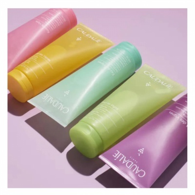 Cinco tubos de creme Caudalie em várias cores sobre fundo rosa