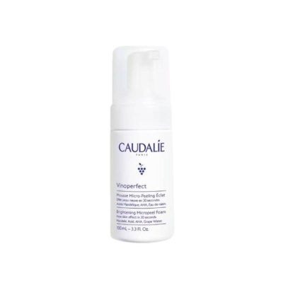 Frasco branco de espuma facial Caudalie Vinoperfect com texto azul e roxo, tampa transparente