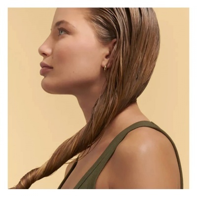 Perfil lateral de mulher com cabelo molhado enrolado e alça verde musgo