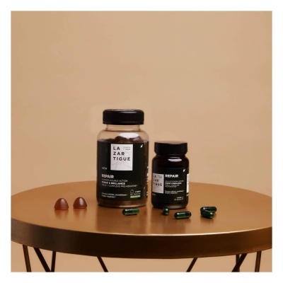 Suplementos LAZARTIGUE REPAIR com cápsulas castanhas e verdes em mesa dourada