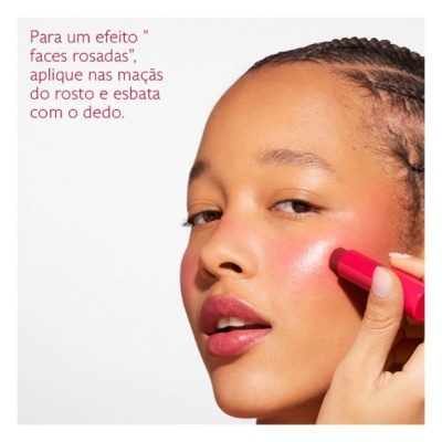 Mulher a aplicar stick cor-de-rosa nas maçãs do rosto com fundo branco e texto em português