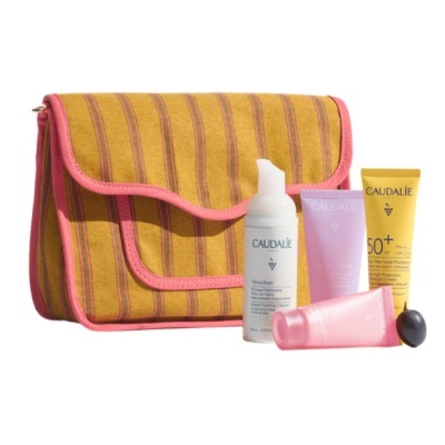 Conjunto Caudalie com bolsa riscada amarela e rosa e três tubos de cosméticos