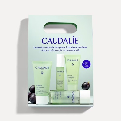 Caixa branca com conjunto de produtos Caudalie para pele acneica com embalagens verdes