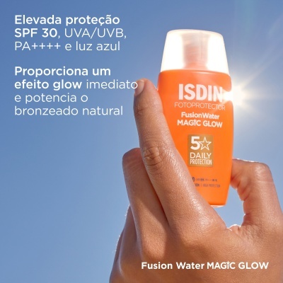 Frasco laranja de protetor solar ISDIN Fusion Water Magic Glow em mão com fundo de céu azul