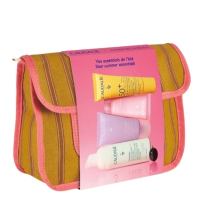 Necessaire às riscas castanho, amarelo e rosa com etiqueta de produtos Caudalie