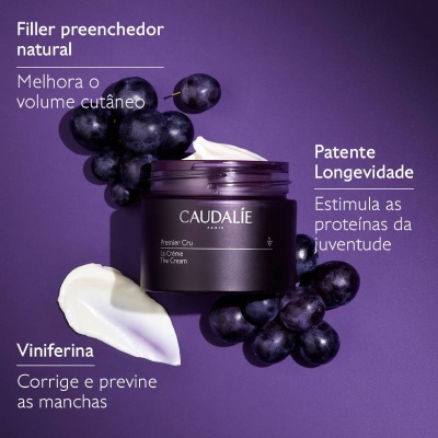 Frasco de creme Caudalie Premier Cru La Crème rodeado por uvas escuras e porções do creme