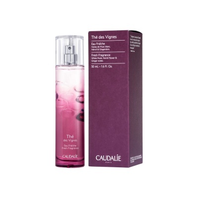 Frasco de perfume rosa com caixa roxa da marca Caudalie