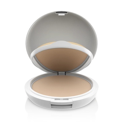Pó compacto de maquilhagem num estojo redondo branco aberto com espelho