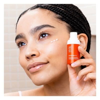 Frasco de creme SYR laranja e branco próximo ao rosto de mulher com pele morena e cabelo trançado