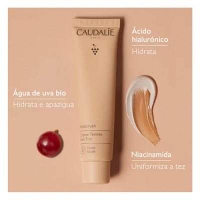 Tubo de creme CAUDALÍE vinho com textura do produto e um grão de uva vermelho em fundo bege