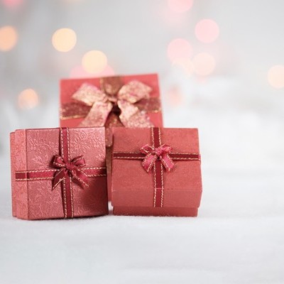 Caixas de presente rosa e vermelhas com laços sobre superfície branca macia