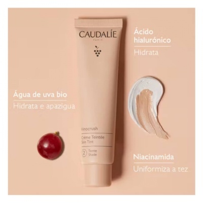Tubo de creme Caudalie com uva vermelha e amostras do produto em fundo rosa