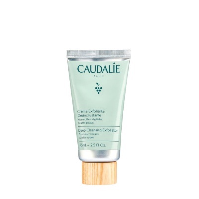 Frasco verde claro de creme esfoliante Caudalie com tampa de madeira clara
