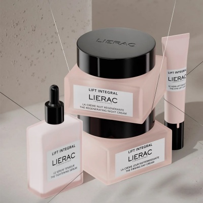 Produtos Lierac Lift Integral em frascos e tubo rosa com tampas pretas sobre superfície cinza