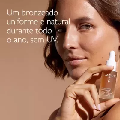 Mulher a segurar frasco de vidro âmbar da marca CAUDALIE