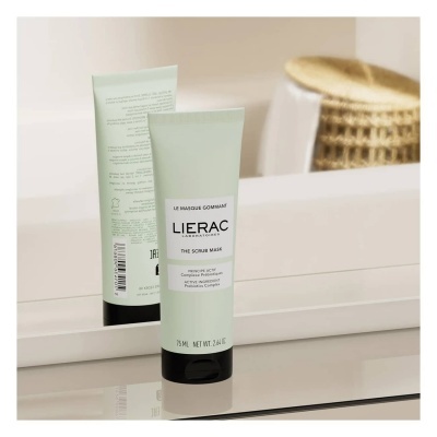 Tubo de creme facial Lierac The Scrub Mask 75 ml sobre superfície branca refletido em espelho.